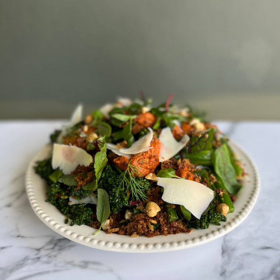 Salad with greens, croutons, and cheese on a marble surface