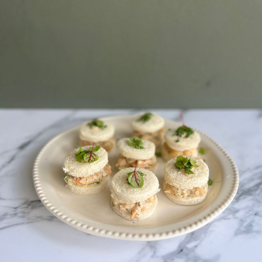 A selectiong of Prawn ribbon sandwiched finger food with prawn on a marble bench top