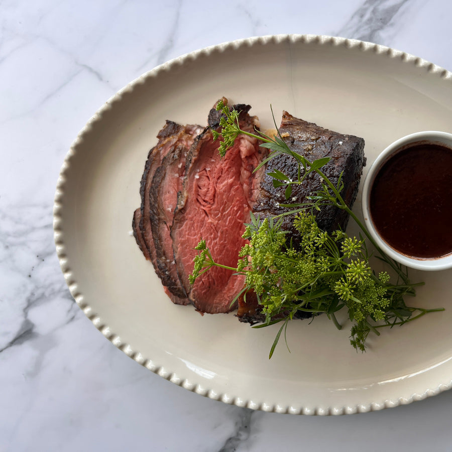 Roasted beef with a side of red wine and shallot reduction on a decorative plate